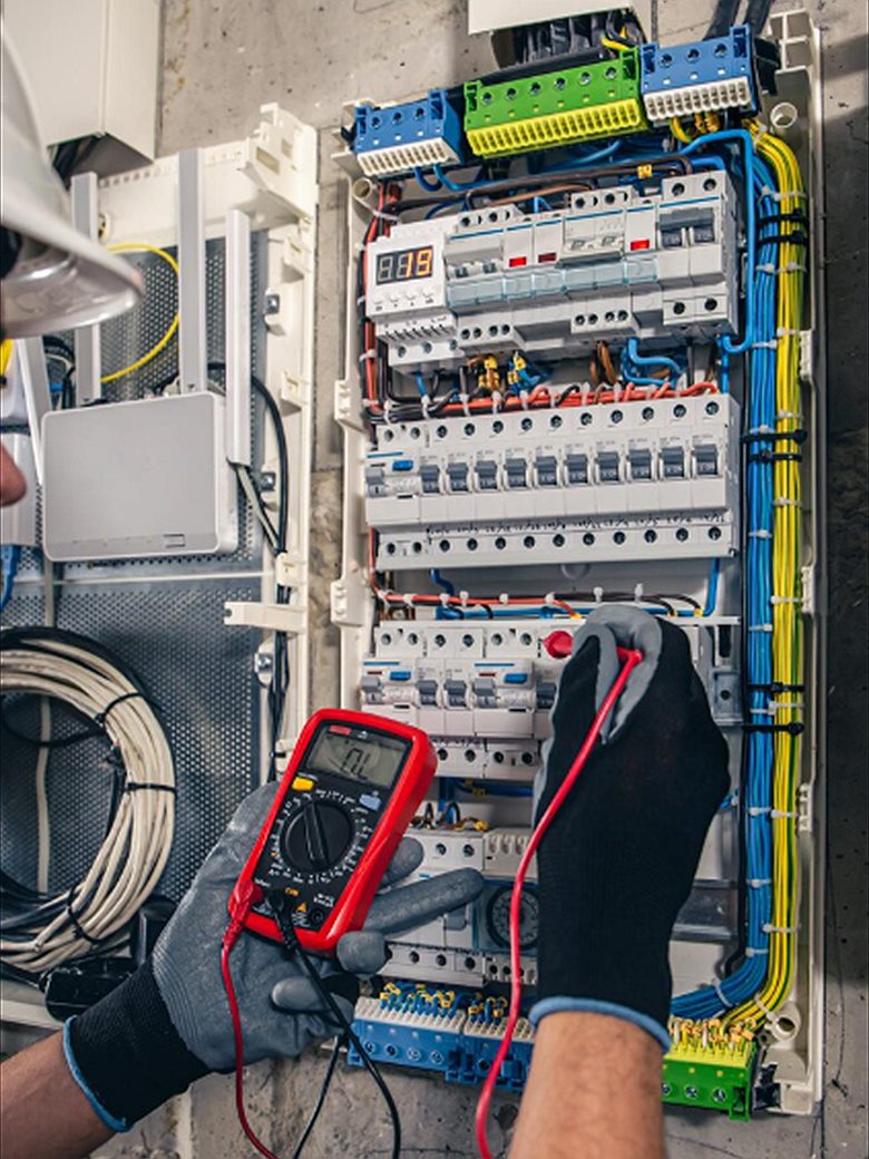 Electrician testing a distribution board with a multimeter